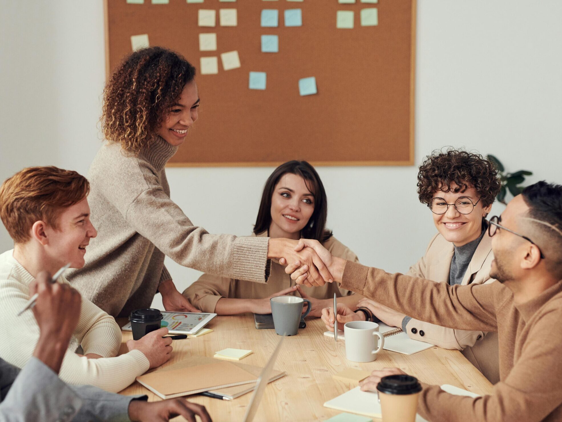 Diverse team collaborating in a meeting, showcasing teamwork and cooperation in a modern workplace.